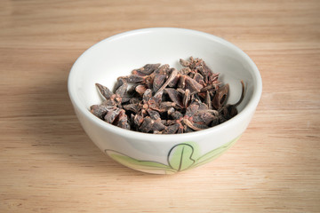 bowl of anise seed on a wood background