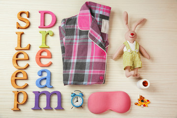 Insomnia concept. Sleeping accessories on light wooden table, top view