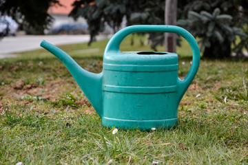 Plastic watering can in grass in the garden