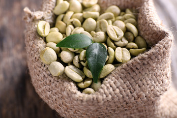Green coffee beans in a bag  on wooden table