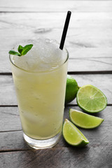 Glass of lemon soda with crushed ice and fresh mint on rustic wooden background