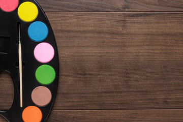 watercolors and brush on the wooden table