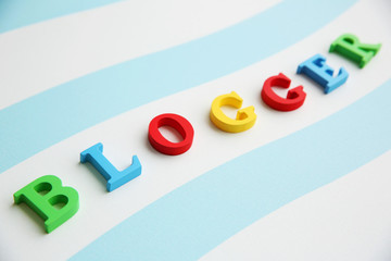 Word BLOGGER made with colorful letters on striped background