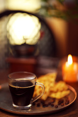 Glass cup of coffee with waffles on dark table