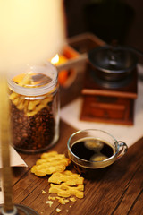 Glass cup of coffee with cookies on dark table