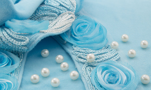 White pearls scattered on turquoise ribbon and silver cord with