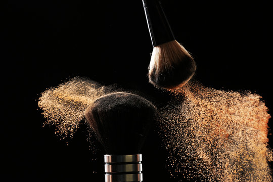 Two Make Up Brushes With Powder On Black Background