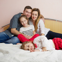 happy young family lying in bed