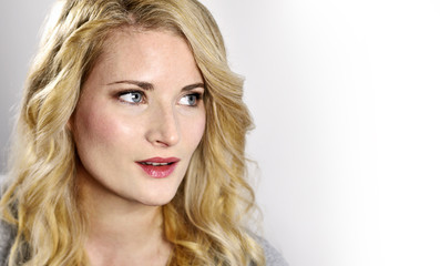 Naklejka premium Beautiful blond woman looking to the side. Portrait of a young woman, low key shot.