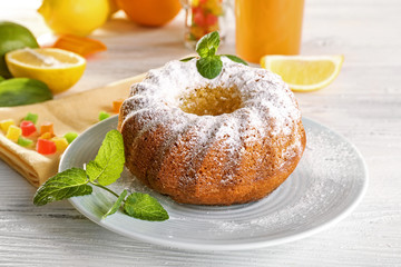 Delicious citrus cake with fruits on wooden table