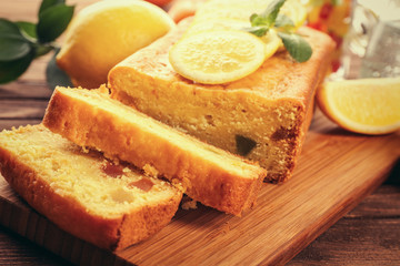 Delicious citrus cake loaf with lemons on wooden board