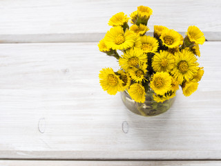 Bouquet of yellow spring flower on a wooden background