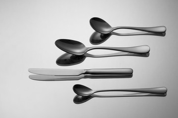 Different types of spoon and a knife on metallic background.
