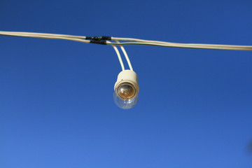 Lamp string hanging against a blue sky background