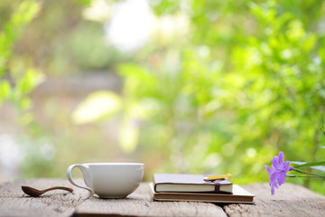 Notebook with pencil and cup on wooden table 