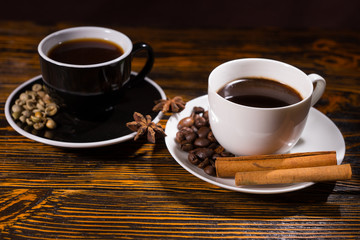 Black and white teacups with coffee and cinnamon