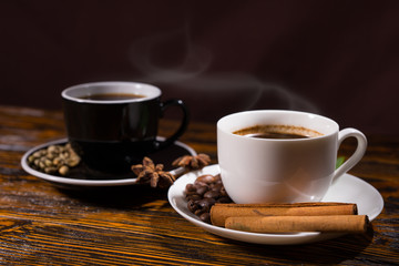 Black and white hot coffee with herbs and beans