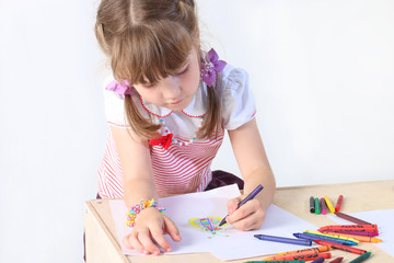 Portrait of little girl paint on paper sheets with crayons