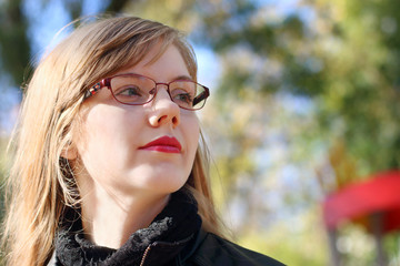 Young smiling woman with long hair looks away at sunny day