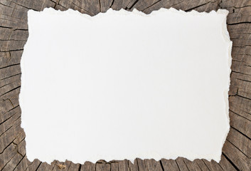 White Blank torn cardboard on the background of a wooden board with cracks