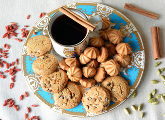 A stack of chocolate chip cookies in vintage blue plate and cup of coffee