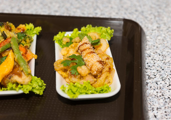Honey glazed meat with lettuce in tray