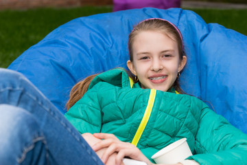 Smiling young girl relaxing on a blue beanbag