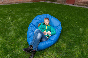 Young girl relaxing in a blue beanbag
