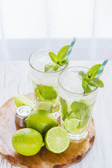 Two fresh mojitos cocktail. Mojitos with mint leaves, lime and ice