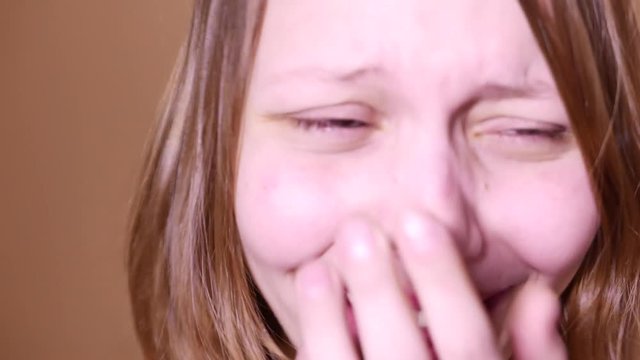 Closeup portrait of an emotional attractive laughing teen girl. 4K UHD