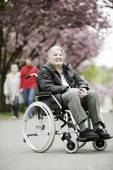 Fototapeta na wymiar Rollstuhlfahrerin im Park