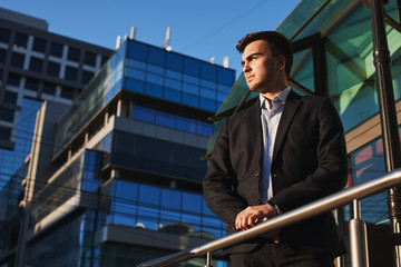 Man in suit on the background of the building with a glass facade