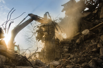 Excavator working at the demolition of an old industrial building.