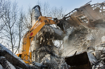 Excavator working at the demolition of an old industrial building.