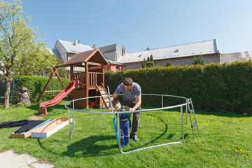 Obraz na płótnie Canvas Father and son when installing large garden trampolines.