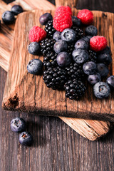 Fototapeta na wymiar blueberries and raspberries on a wooden background