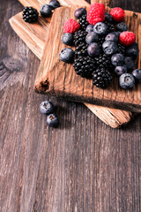 Fototapeta na wymiar blueberries and raspberries on a wooden background