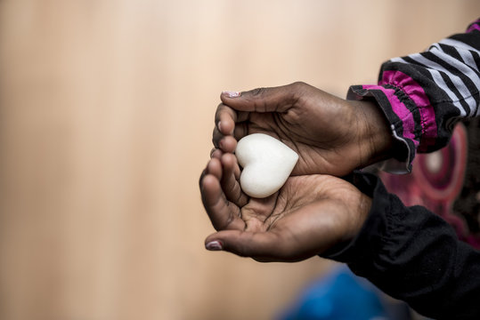 Closeup of African-American girl holding a marble made heart sha