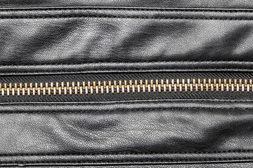 Black leather jacket metal zipper closeup.