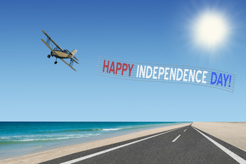 happy independence day banner with american flag colors at beach and plane flying over road