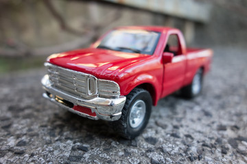 Obraz na płótnie Canvas Red pick up truck toy on the road. Shallow depth of field