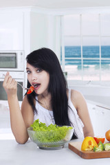 Woman enjoy salad in the kitchen