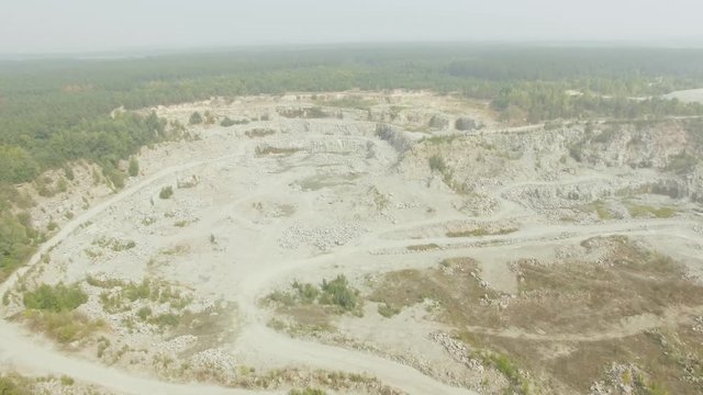 Aerial shot of granite extraction canyon in forest countryside area