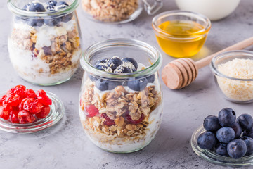 Glass jars of oat flakes with fruit, yogurt and honey.