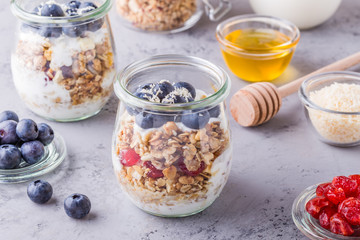 Glass jars of oat flakes with fruit, yogurt and honey.
