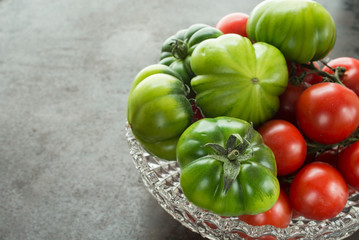 Grüne und rote Tomaten in einer Schale