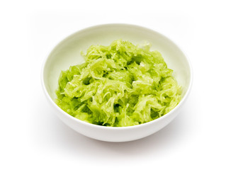 Grated cucumber in white dish, isolated on white background.