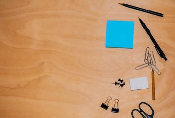 Business background with note paper, pen and paperclips on office table. View from above