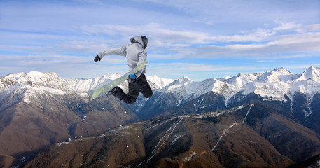 Obraz premium Snowboard rider jumping on mountains. Extreme snowboard freeride sport.