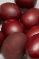 Colorful Easter eggs in a white plate on old wooden table backgr
